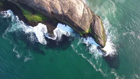 Vertical shot of stone with waves crashing on the shore. Video stock 81133084
