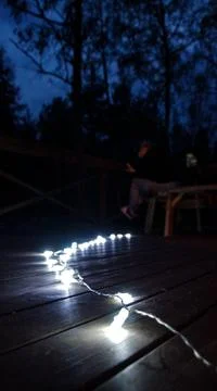 Vertical shot of a string of illuminated lights outdoors Stock Photos