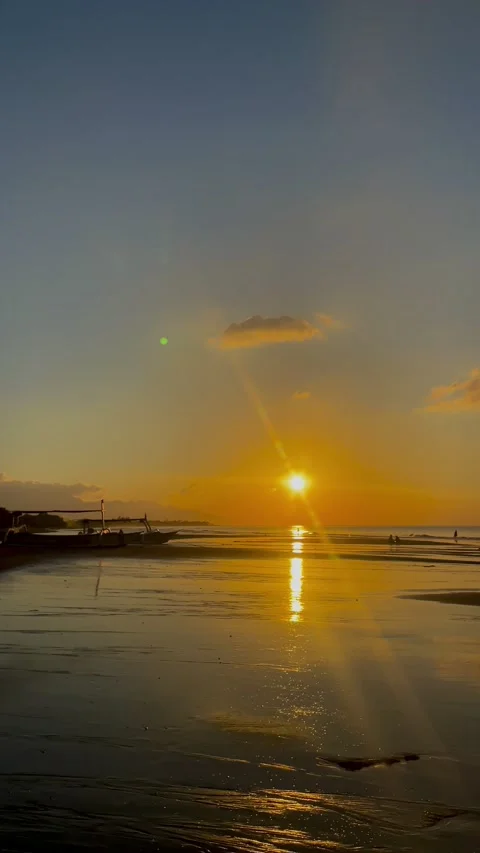 Vertical shot of stunning beach sunset with cloud reflection in Bali 動画素材 343796675