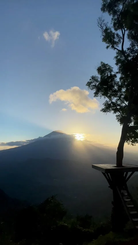 Vertical Shot of Sunbeams Bursting Behind Mount Agung at Sunrise Vidéo 341552162