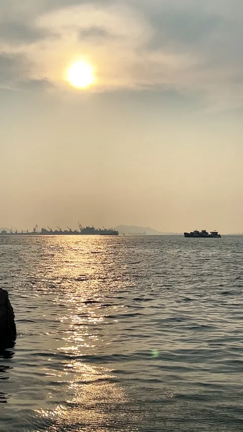 Vertical shot of the sun's reflection on waves at sunset Stock Footage 238416541