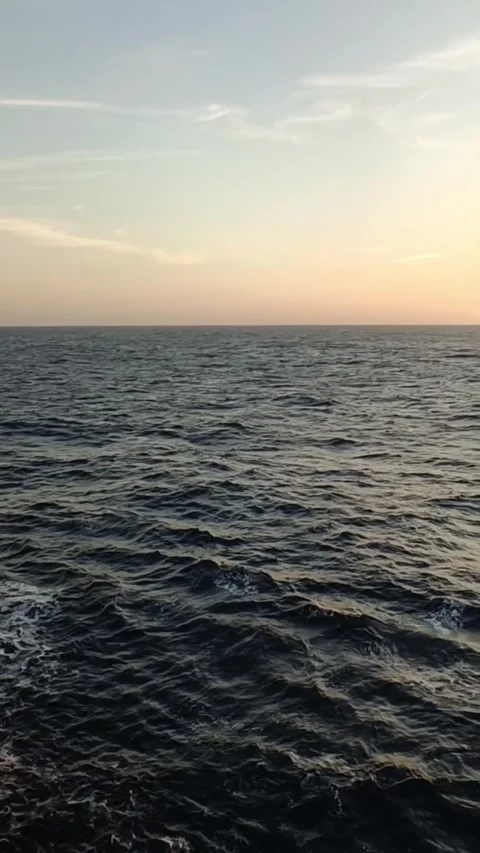 Vertical shot of sunset over the ocean from a cargo ship deck Video stock 336392144