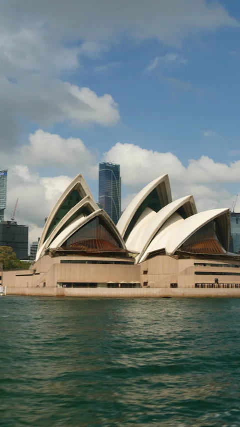 Vertical shot of Sydney Opera House and high-rise buildings from boat Vídeos de archivo 303346332