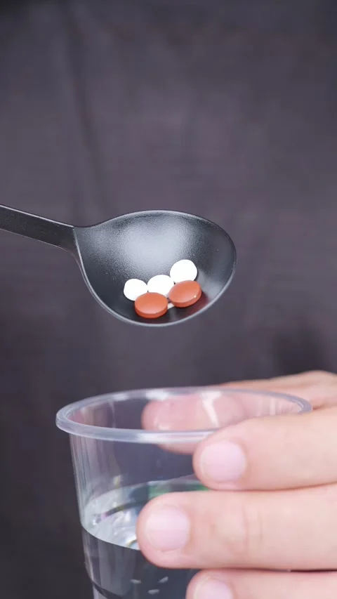 Vertical shot: Take medicine from spoon toward mouth. Vídeo Stock 344831694