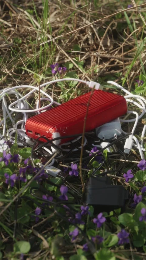 Vertical shot of technogenic e-waste among forest flowers Stock Footage 333118448