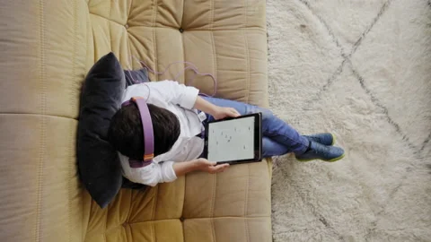 Vertical shot of top view of a caucasian boy with helmets playing with a tabl Video stock 150664770