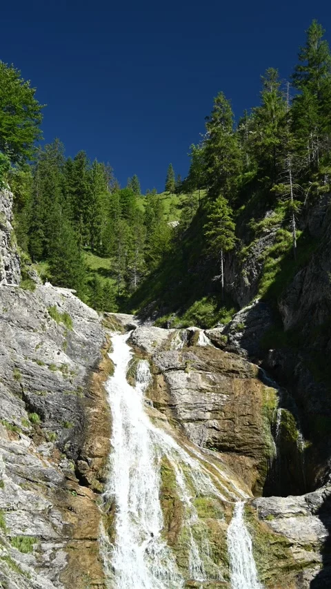 Vertical shot of the top of a waterfall with ponds in the Bavarian Alps Stock-Footage 260877112