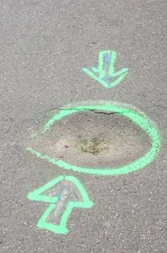 Vertical shot of two arrows pointing at a circle painted on the ground Foto stock