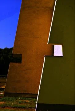 Vertical shot of two multi-colored walls parallel to each other a blue sky backg 库存照片