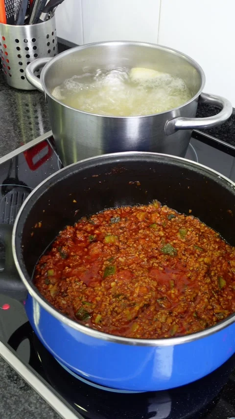 Vertical shot of two pots cooking pasta bolognese Stock Footage 283276621
