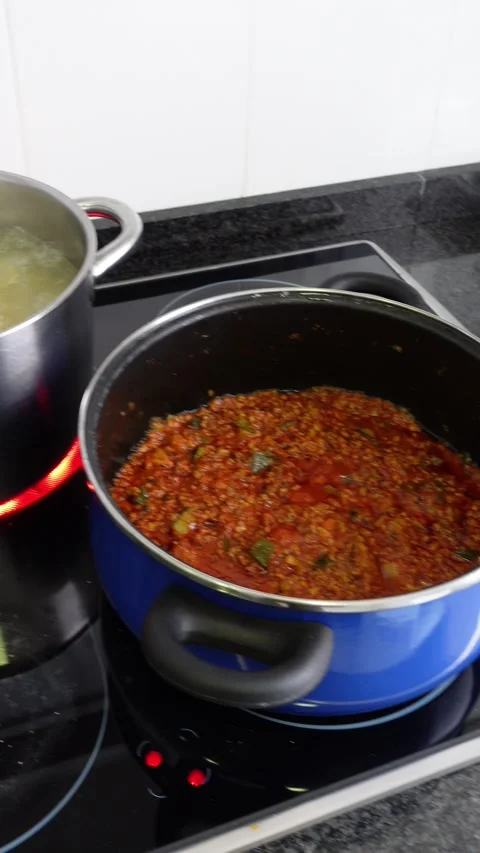 Vertical shot of two pots cooking pasta bolognese Stock Footage 342494543