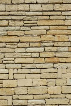 Vertical shot of a wall made of irregular brick stones for background Stock Photos