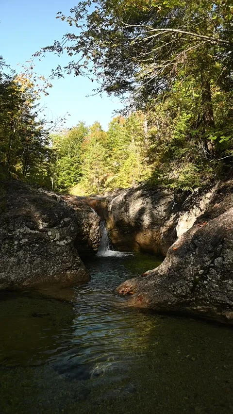 Vertical shot of a waterfall and a mountain stream in autumn, slow motion Video stock 260927095