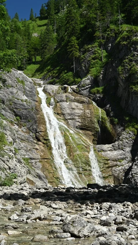 Vertical shot of a waterfall in the mountains and a mountain stream in front Stock-Footage 260874345