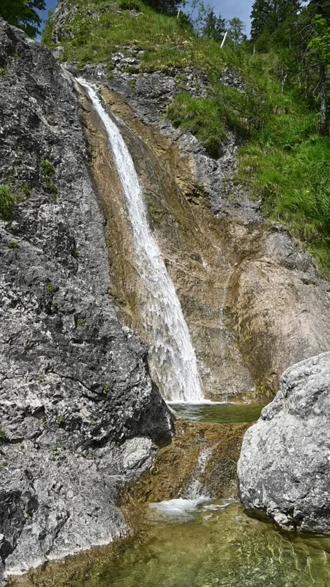 Vertical shot of a waterfall in summer sunlight, slow motion Stock Footage 260887677