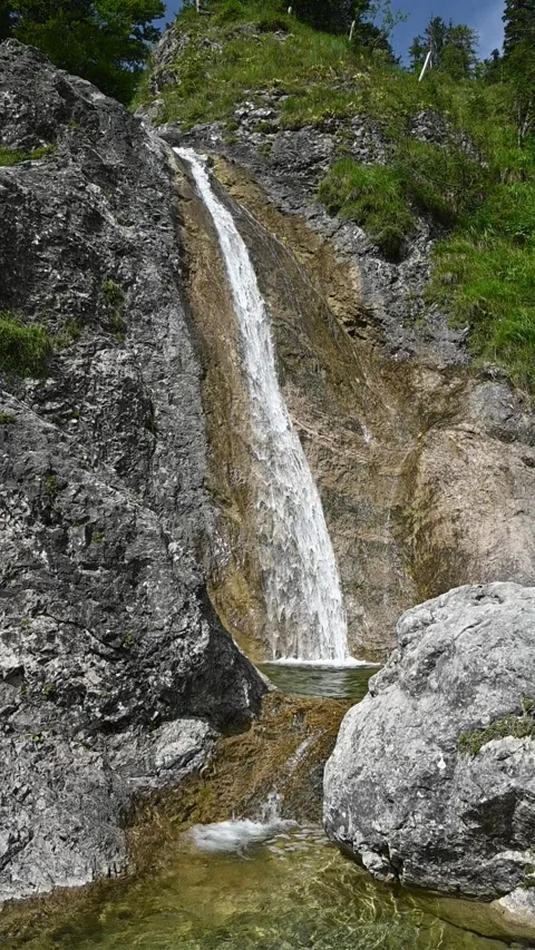 Vertical shot of a waterfall in summer sunlight, slow motion Stock-Footage 260887778