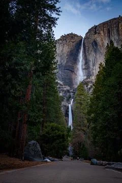 Vertical shot of a waterfall surrounded by cliffs and trees Stock Photos