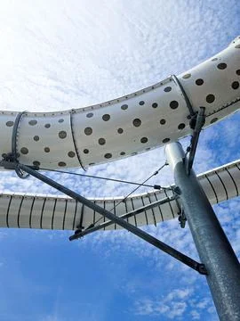 Vertical shot of white pipes with patterns against a cloudy sky in waterpark Stock Photos