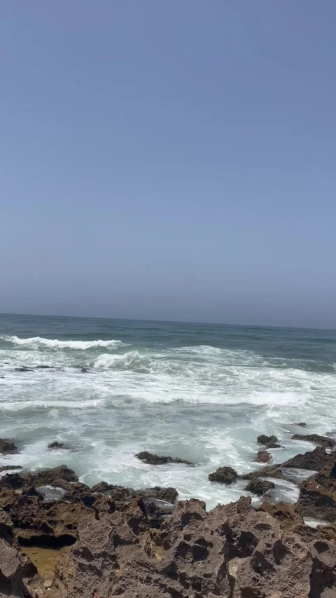 Vertical Shot of White Waves Breaking on Rocky Shore Stock Footage 340775144