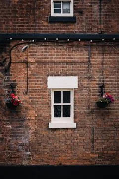 Vertical shot of a white window on an old brick wall of a house building Fotos de archivo