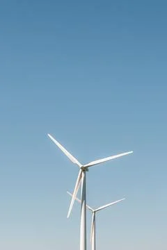 Vertical shot of a wind farm against the blue sky in Lauterbach town in Germany Ilustração Stock