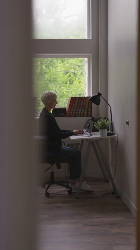Vertical Shot of Woman with Short Pixie Cut Typing on computer at home Stock Footage 208777989