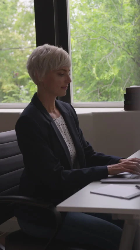 Vertical Shot of Woman with Short Pixie Cut Typing on Keyboard in office Stock Footage 208778206