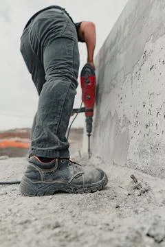 Vertical shot of a worker doing installation work during construction Stock Photos
