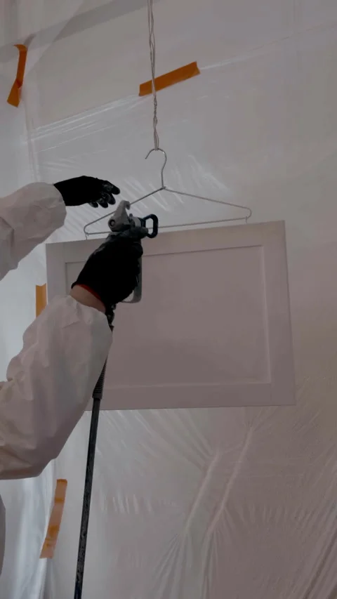 Vertical shot of Worker using a spray gun to apply paint or coating inside Видео 334024145