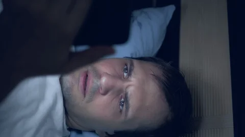 Vertical shot of a young man uses a smartphone in bed at night Stock-Footage 129255096
