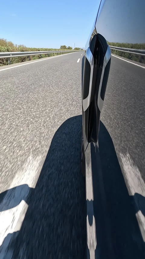 Vertical side of a car driving on an highway with sunny blue sky Stock Footage 332065236