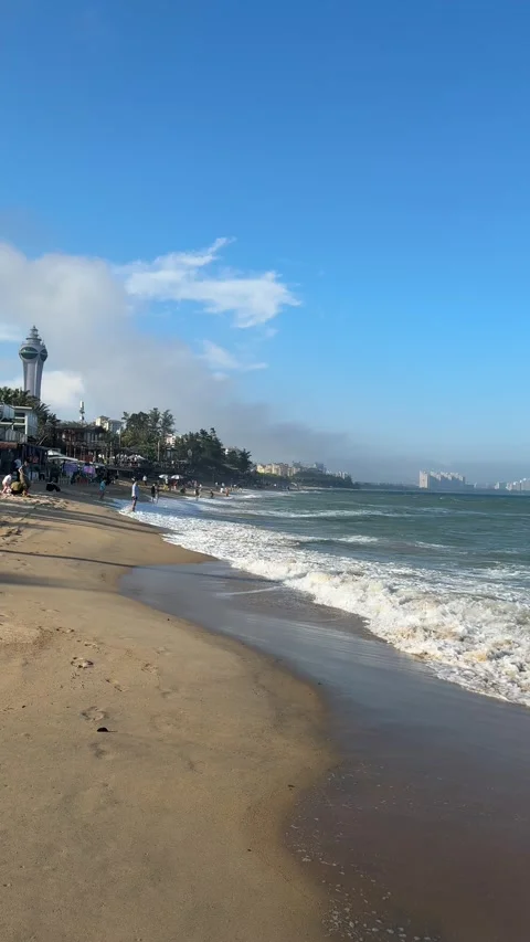 Vertical Side View of Tourists and Modern Resorts on Qionghai Beach 4K Vídeos de archivo 331971434