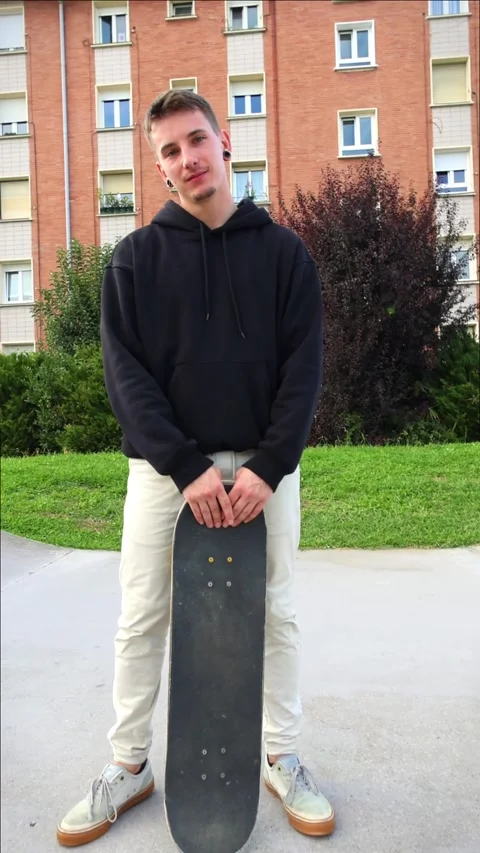 Vertical Skater Posing Confidently with Skateboard in Skate park as Camera .. Stock Footage 285766327