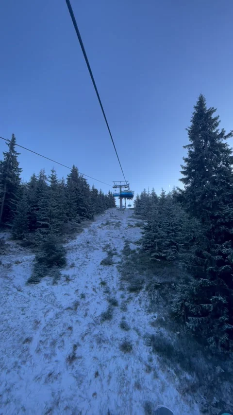 Vertical ski lift moving above frosted pine forest on mountain slope Stock Footage 325647628