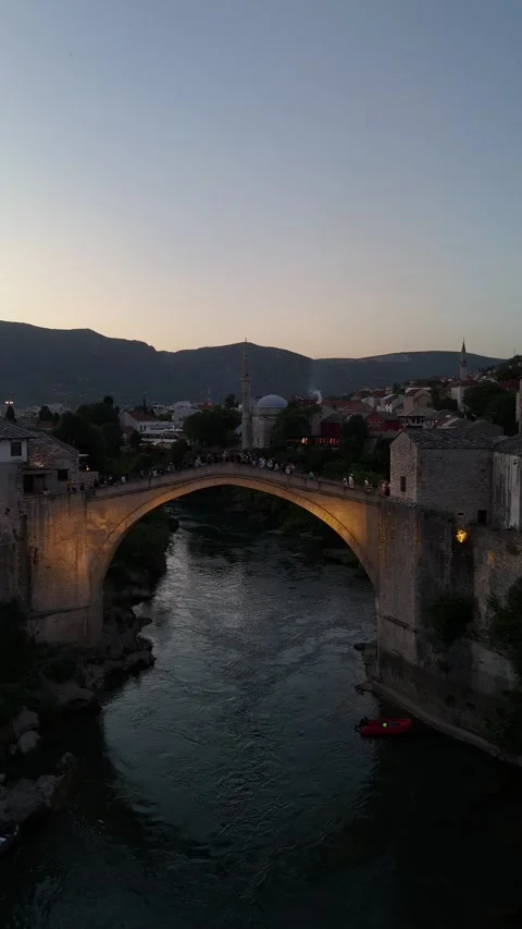 Vertical Slow Drone Push Forward to Lit Up Stari Most Bridge and Pedestrians 4K Stock Footage 337830930