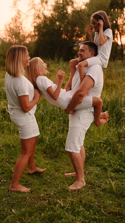 Vertical slow motion cheerful happy family dad mom daughters have fun playing Stock Footage 204810543