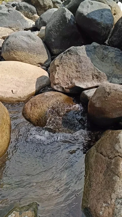 Vertical slow motion clear mountain stream flowing between smooth boulders Stock Footage 342965012