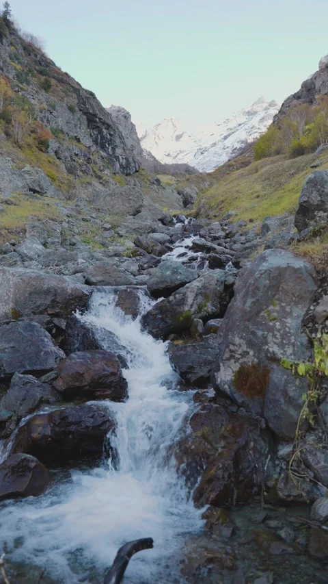 Vertical Slow Motion Close Up of Alpine Water Cascading Over Rocks in Autumn Видео 330440920