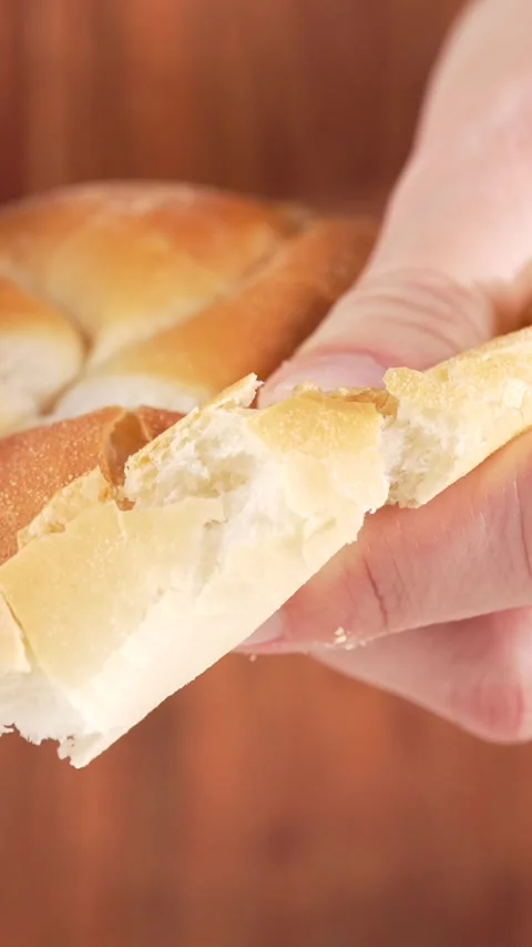 Vertical slow motion close-up of hands tearing freshly baked soft bun, reve.. Stock Footage 312169440