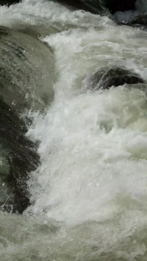 Vertical slow motion of a fast flowing rocky mountain river Stock Footage 320954842
