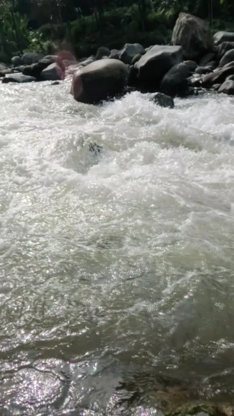 Vertical slow motion of a fast flowing river in the rocky mountains Video stock 320977949