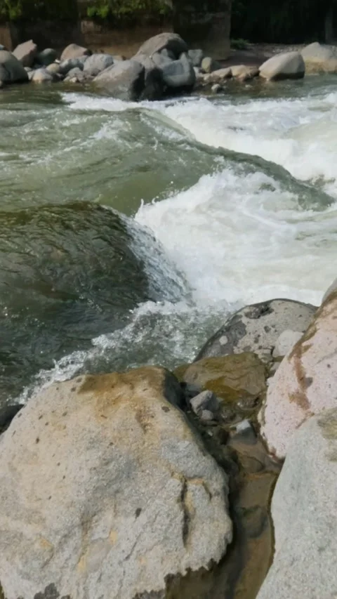 Vertical slow motion of a fast flowing river in the rocky mountains Video stock 320977994