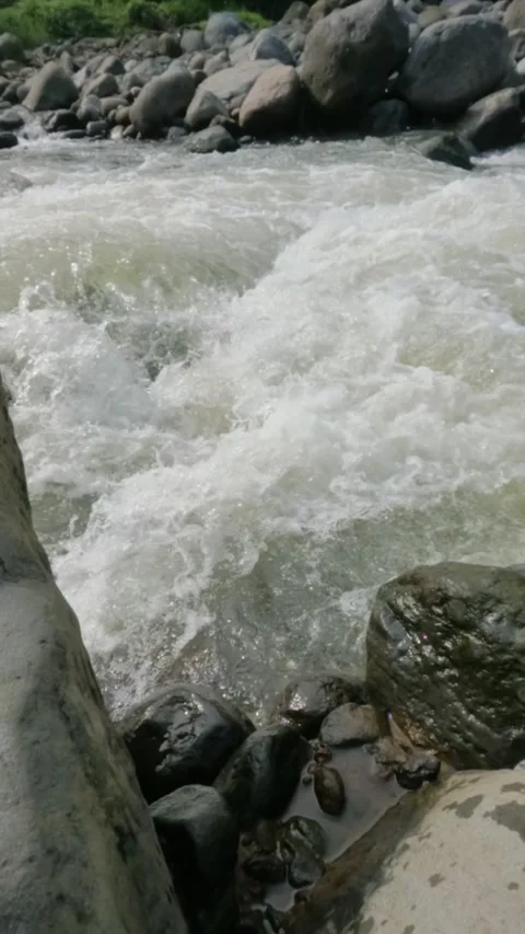 Vertical slow motion of a fast flowing river in the rocky mountains Video stock 320978002