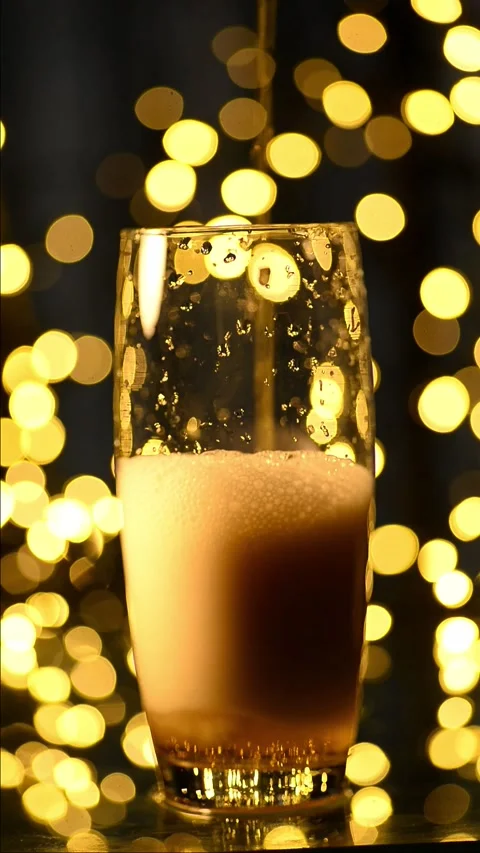 Vertical slow motion of fresh beer pouring slowly into a glass cup Stock Footage 342093419