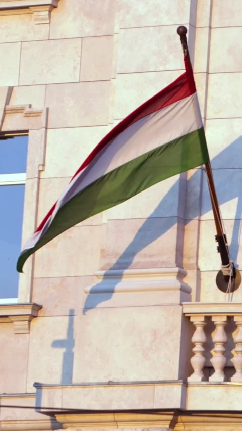 Vertical slow motion of Hungary flag waving on building facade in Budapest Stock Footage 290478262