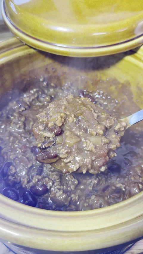 ​Vertical - Slow motion of a ladle lifting chilli con carne from a slow cooker. Video stock 300474650