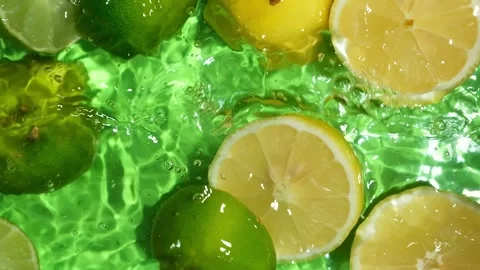 Vertical Slow Motion of Lime Halves and Lemons Falling into Water. Stock Footage 346203954