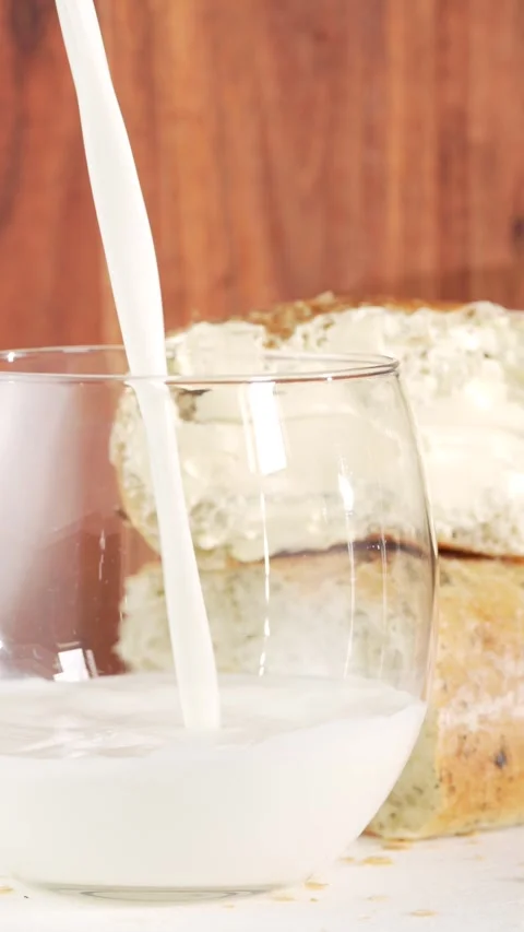 Vertical Slow Motion of Milk Pouring into Glass with Fresh Spinach Buns in .. Stock Footage 312169730