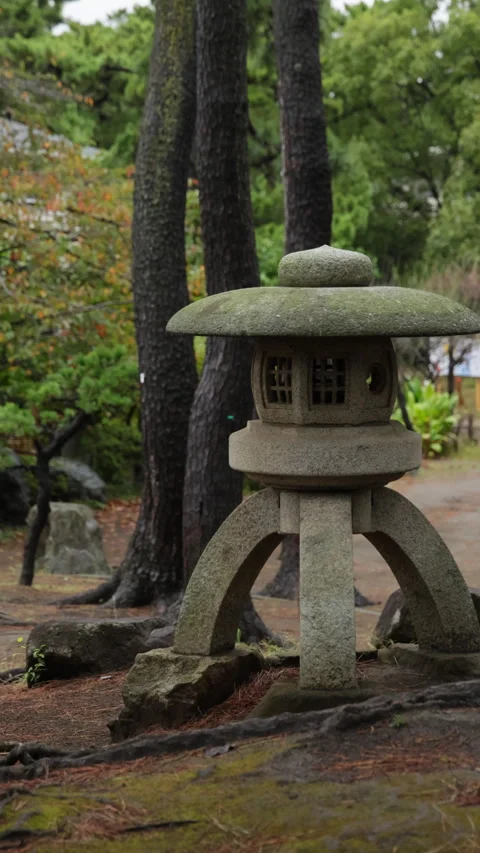 Vertical slow motion moss covered stone lantern in a Japanese park Video stock 348585239
