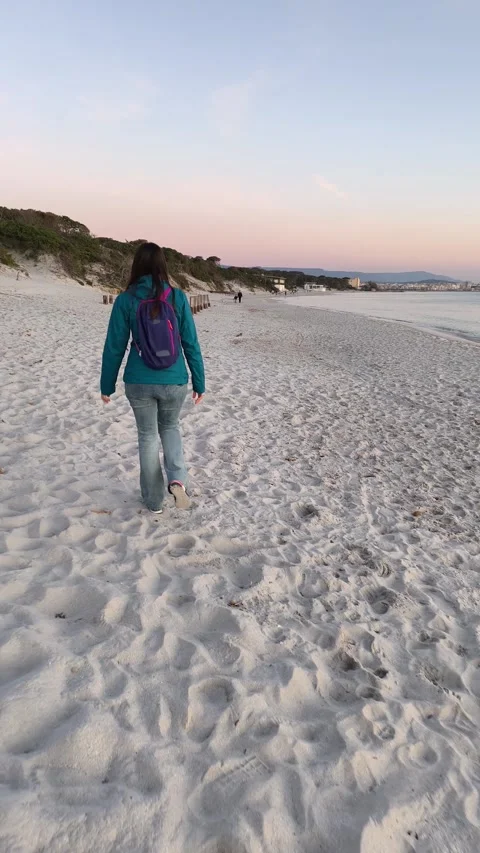 Vertical Slow Motion Rear View of Woman Walking on the Beach at Sunset in Winter Stock Footage 346644339